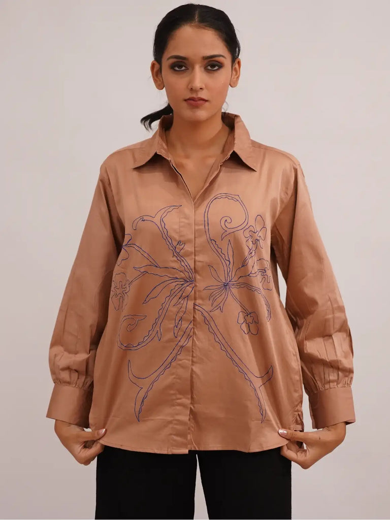 Woman wearing a brown embroidered shirt