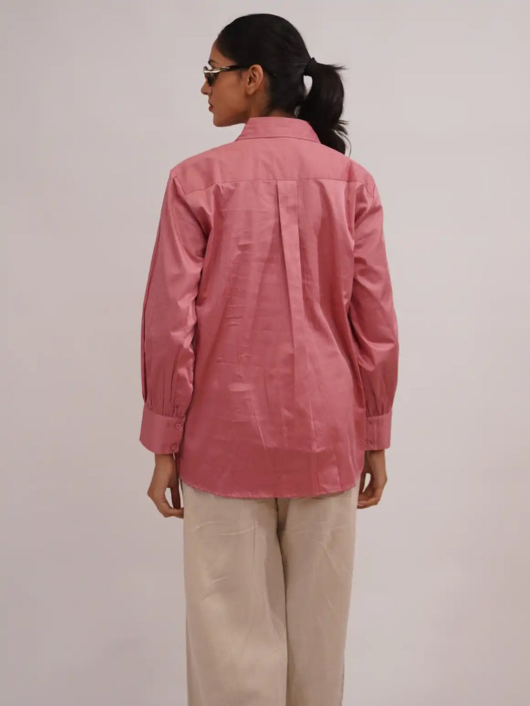 Woman styled in a pink shirt with embroidery