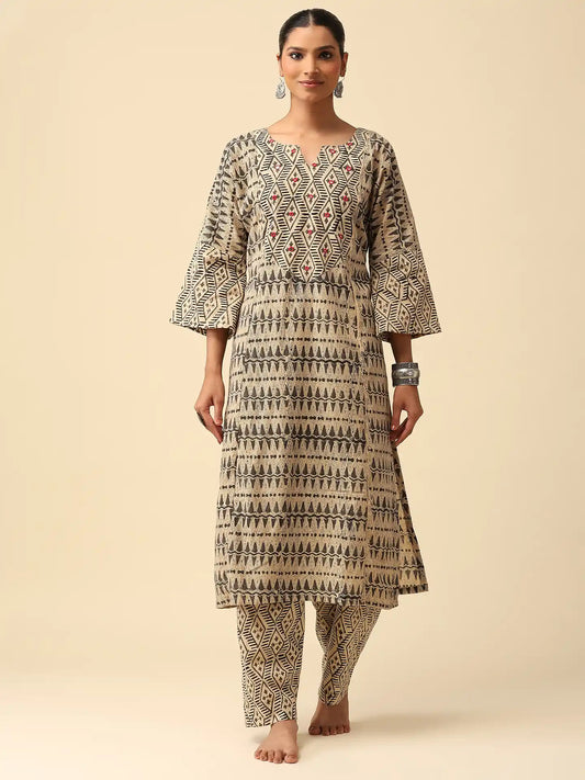 Woman wearing a patterned kurta with pants on a beige background