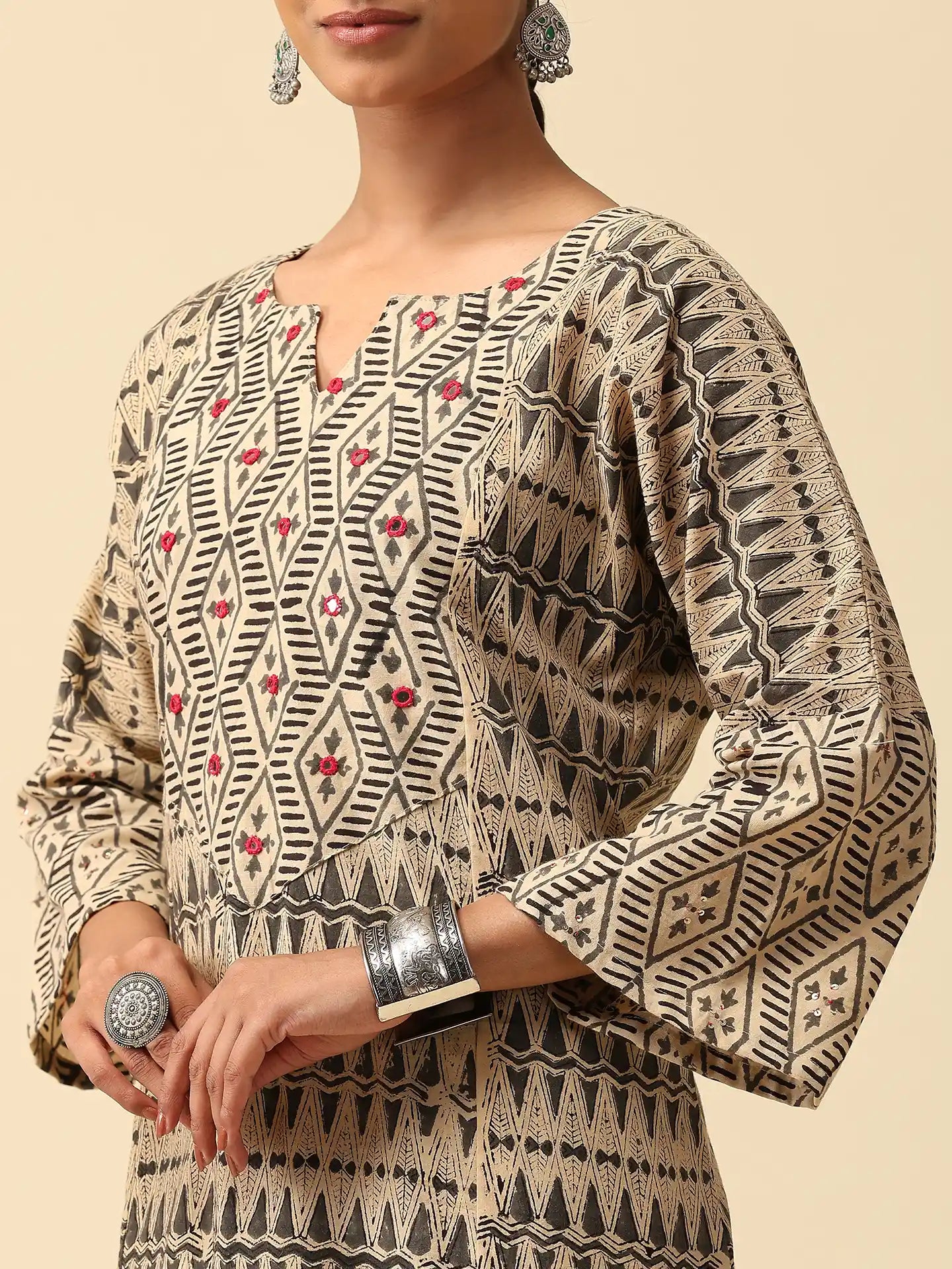 Woman wearing a patterned kurta with bell sleeves on a beige background